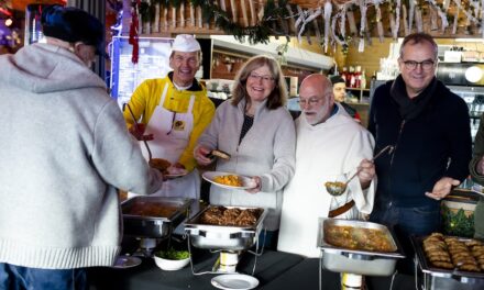 Gäste der Armenküche genießen festliches Mittagessen in der Füchschen Alm