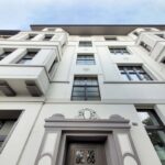 Erste geförderte Projekte im Hof- und Fassadenprogramm Rath/Mörsenbroich sind erfolgreich umgesetzt   Gründerzeithaus in Mörsenbroich erstrahlt in neuem Glanz – Urban Art am Rather Broich setzt kreative Akzente    Die ersten beiden geförderten Sanierungsprojekte im Rahmen des Hof- und Fassadenprogramms Rath/Mörsenbroich sind abgeschlossen – mit sichtbarem Erfolg: In Mörsenbroich wurde ein historisches Gründerzeithaus behutsam saniert, am Rather Broich entstand ein großflächiges Urban-Art-Graffiti, das dem Quartier neue Impulse verleiht.  Gründerzeithaus erstrahlt in neuem Glanz Das Gründerzeithaus der Familie Jacobs in Düsseldorf-Mörsenbroich zeigt eindrucksvoll, wie denkmalgerechte Sanierung sowie energetische und schallschutztechnische Verbesserung Hand in Hand gehen können.  Der erste Beratungstermin mit Quartiersarchitektin Nathalie Unger fand spätabends in Mörsenbroich an der Münsterstraße statt. Familie Jacobs hatte eingeladen, um gemeinsam das Sanierungspotenzial ihrer Immobilie zu bewerten. Schnell war klar: Eine energetische Sanierung sollte erfolgen – jedoch nicht auf Kosten der historischen Fassadenstruktur. Eine Dämmung mit vollständiger Verkleidung kam nicht infrage, da die massive Bauweise bereits gute Dämmwerte bietet. Die größte Schwachstelle waren die alten Holzfenster – handwerklich hochwertig, aber nicht mehr zeitgemäß in Bezug auf Wärme- und Schallschutz.  Die Lösung: Ein Austausch der Fenster unter Erhalt der historischen Optik. Die feine Sprosseneinteilung und die schlanken Rahmen sollten auch die neuen Fenster haben. Dank der städtischen Schallschutzfensterförderung konnte eine passende Lösung gefunden werden, die sowohl den Anforderungen an den Denkmalschutz als auch an den modernen Wohnkomfort gerecht wird.  Im zweiten Schritt wurde über das Hof- und Fassadenprogramm die Sanierung der Fassade gefördert. Die Farbgestaltung wurde behutsam überarbeitet – bewährte Elemente blieben erhalten, neue Nuancen wurden abgestimmt, um die architektonische Komposition optimal zur Geltung zu bringen.  “Die Beratung war unkompliziert und sehr hilfreich. Wir hätten nicht gedacht, dass die Förderung so gut zu unserem Haus passt – und dass wir dabei die historische Optik erhalten können”, sagen die Eigentümer.  Urban Art bringt Farbe ins Viertel Auch an der Kreuzung Rather Broich/Sankt-Franziskus-Straße zeigt das Programm Wirkung: Dort entstand ein großflächiges Urban-Art-Graffiti, das nicht nur die Umgebung visuell aufwertet, sondern auch ein klares Statement für die Wertschätzung handwerklicher Arbeit setzt.  “Die ersten erfolgreich umgesetzten Projekte sind ein sichtbarer Gewinn für das Quartier – und ein Beispiel dafür, wie private Initiative und öffentliche Förderung gemeinsam zur Aufwertung der Stadtteile Rath und Mörsenbroich beitragen können”, bestätigt Cornelia Zuschle, Beigeordnete für Planen, Bauen, Wohnen und Grundstückswesen der Landeshauptstadt Düsseldorf.  Fördermöglichkeiten Bis zu 300 Euro pro Quadratmeter Fensterfläche können über die Schallschutzfensterförderung der Stadt Düsseldorf bezuschusst werden, wenn die entsprechenden Voraussetzungen vorliegen. Und für Fassadenanstrich und ‑begrünung sind bis zu 50 Prozent der Kosten über das Hof- und Fassadenprogramm förderfähig.  Informationen, Anträge und Kontakt Die Richtlinie und die notwendigen Formulare stehen digital unter www.duesseldorf.de/rath.moersenbroich zur Verfügung.  Quartiersarchitektin Nathalie Unger ist während ihrer Sprechzeiten zum Hof- und Fassadenprogramm dienstags von 12 bis 17 Uhr unter der Rufnummer 0221–96024185 sowie per E‑Mail an rath-moersenbroich@duesseldorf.de erreichbar. Weitere Termine nach Vereinbarung.  Hintergrundinformationen Das Integrierte städtebauliche Entwicklungskonzept (ISEK) Rath/Mörsenbroich – Mitten am Stadtrand wurde am 17. Mai 2023 durch den Rat der Landeshauptstadt Düsseldorf beschlossen. Im Rahmen des Förderprogramms “Sozialer Zusammenhalt” werden durch verschiedene Projekte rund 10,2 Millionen Euro bis Ende der zweiten Förderphase investiert. Eine Bewilligung für eine zusätzliche EFRE-Förderung (Europäischer Fonds für Regionalentwicklung) erfolgte für die Projekte Grünzug Aaper Wald und Erweiterung des Abenteuerspielplatzes Mörsenbroich. Mehr Informationen zum Projekt und den schon realisierten und geplanten Projekten gibt es auch unter www.duesseldorf.de/rath.moersenbroich.