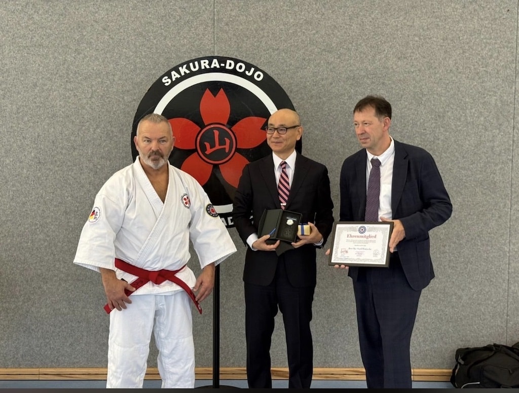 Hohe Ehrung im Rahmen des 18. Internationalen Jujitsu-Lehrgangs in Düsseldorf (v.l.): Kalla Bergers, Trainer und Gründungsmitglied des Sakura Dojo, der japanische Generalkonsul Yoshitaka Tsunoda und Stadtdirektor Burkhard Hintzsche, der mit der Ehrenmitgliedschaft der Europäischen Jujitsu Union ausgezeichnet wurde. © Screenshot Landeshauptstadt Düsseldorf