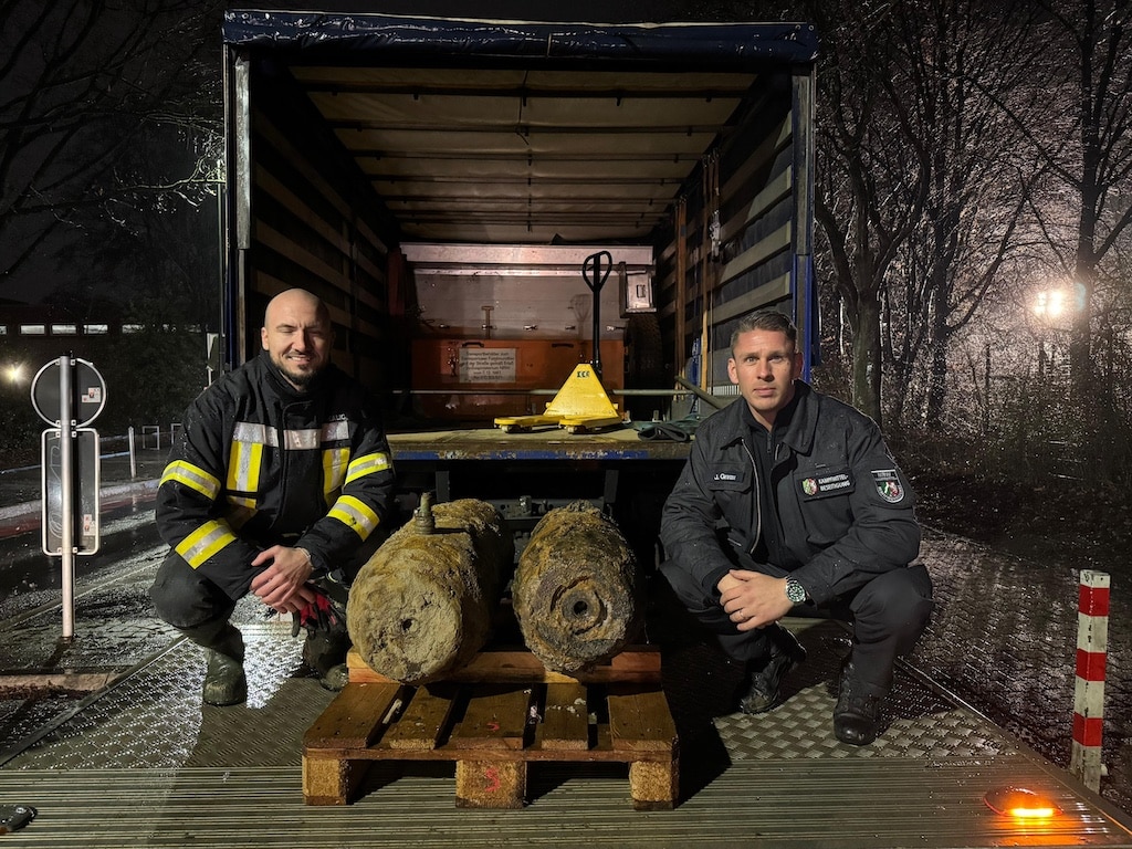 Entschärfer Julian Granzow (r.) vom Kampfmittelbeseitigungsdienst der Bezirksregierung mit seinem Kollegen Adis Kalic und den zwei entschärften Fliegerbomben aus dem Zweiten Weltkrieg. © Feuerwehr Düsseldorf